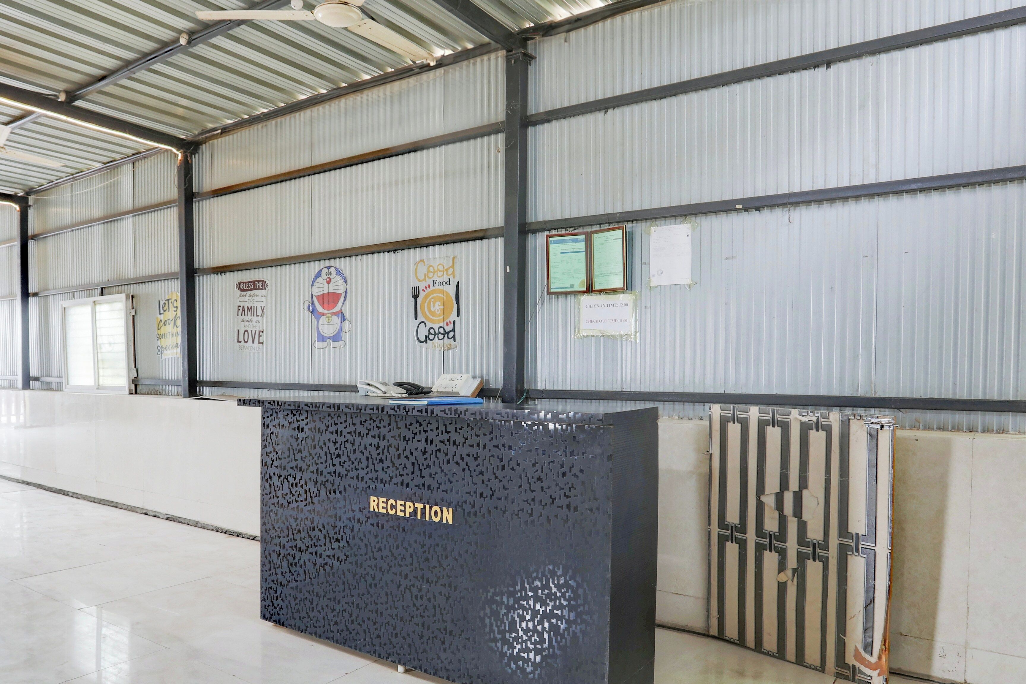 Un espace d’accueil avec un comptoir portant l’inscription « RÉCEPTION » et un mur orné de divers panneaux et affiches.