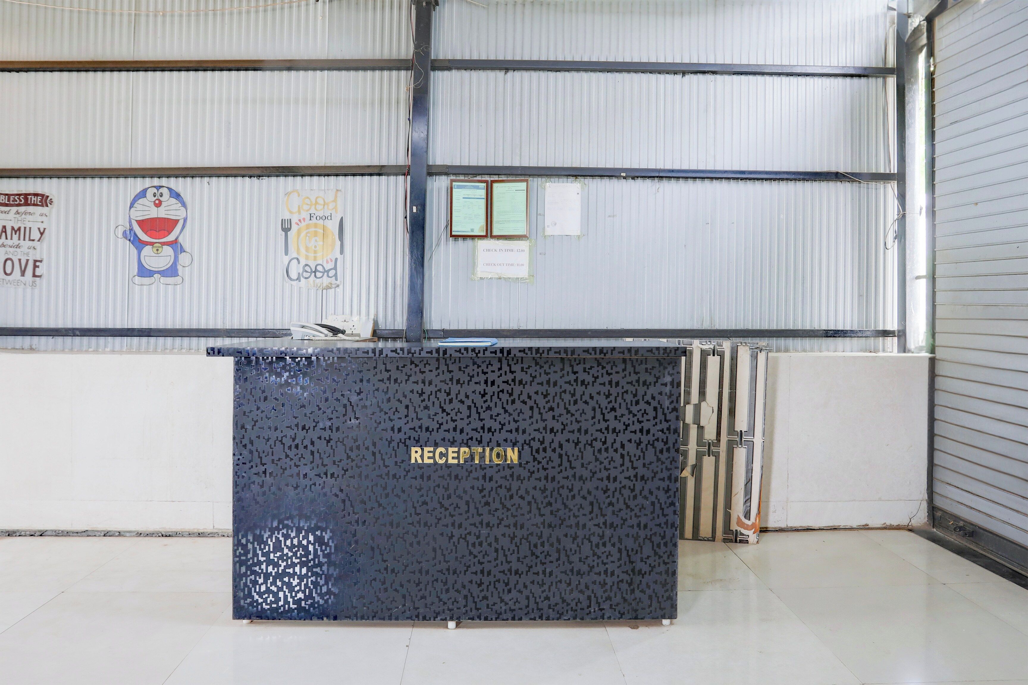 A reception desk with a dark patterned backdrop and the word 'RECEPTION' in gold letters.