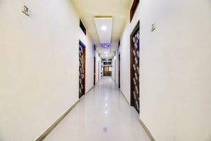 Un pasillo largo y estrecho con puertas a ambos lados, que conduce a una habitación al final.
