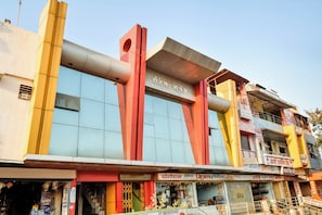 Un edificio de varios pisos con un letrero llamativo en un alfabeto extranjero, que sugiere un hotel o establecimiento comercial.
