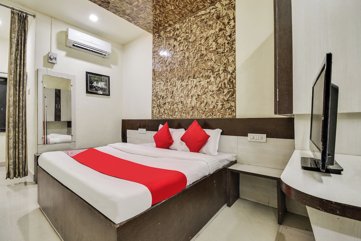 Habitación de hotel con cama, televisión, baño y una pared con textura.