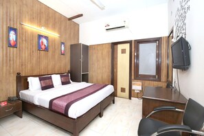 A hotel room with a bed, desk, chair, wardrobe, and a television. - Hotel O H.K.Continental (Amritsar)