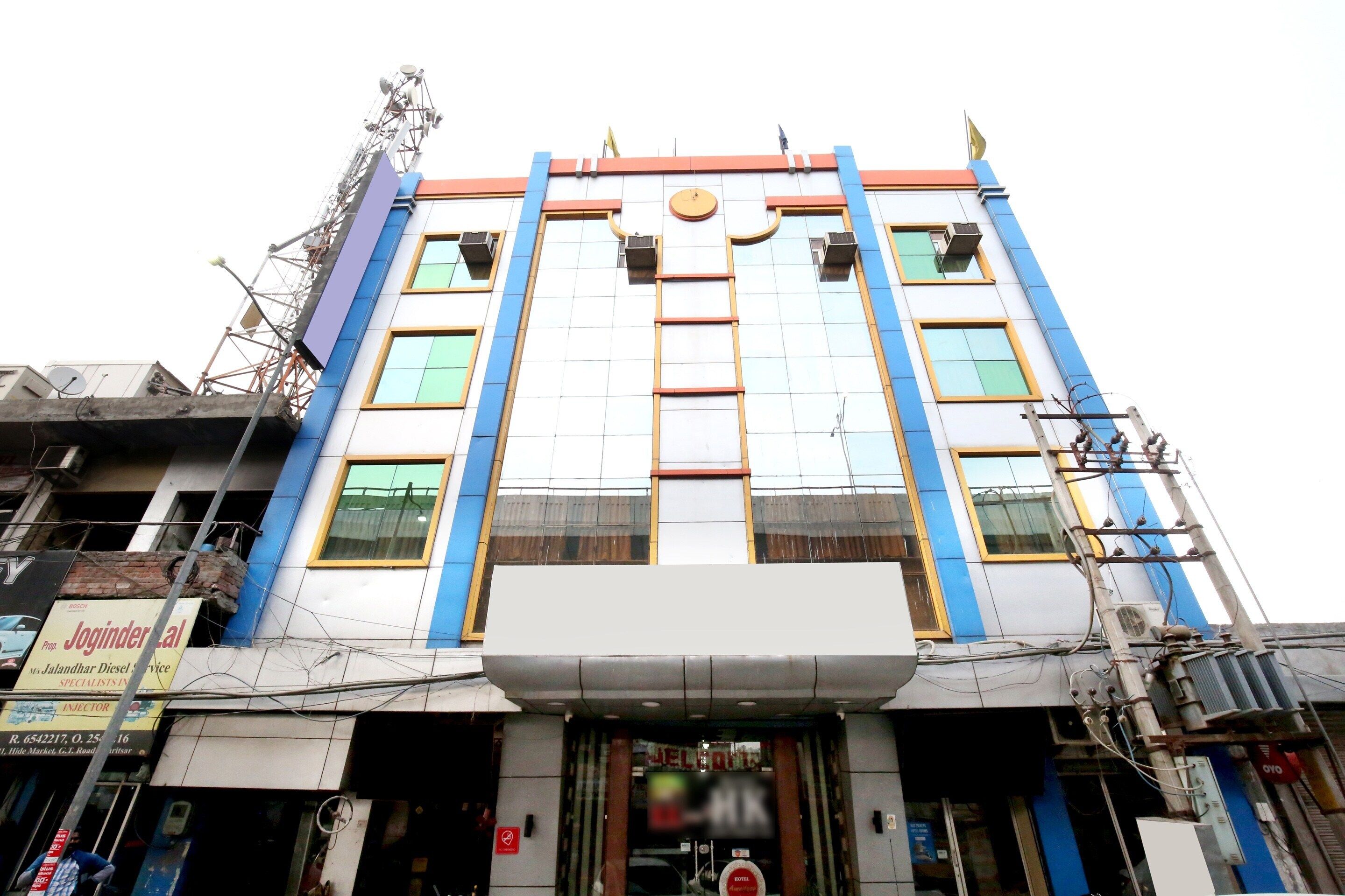 A multi-story hotel with a central entrance, large windows, and a flat roof.
