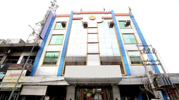 Un hotel de varios pisos con entrada central, ventanas amplias y tejado plano.