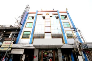 A multi-story hotel with a central entrance, large windows, and a flat roof. - Hotel O H.K.Continental (Amritsar)