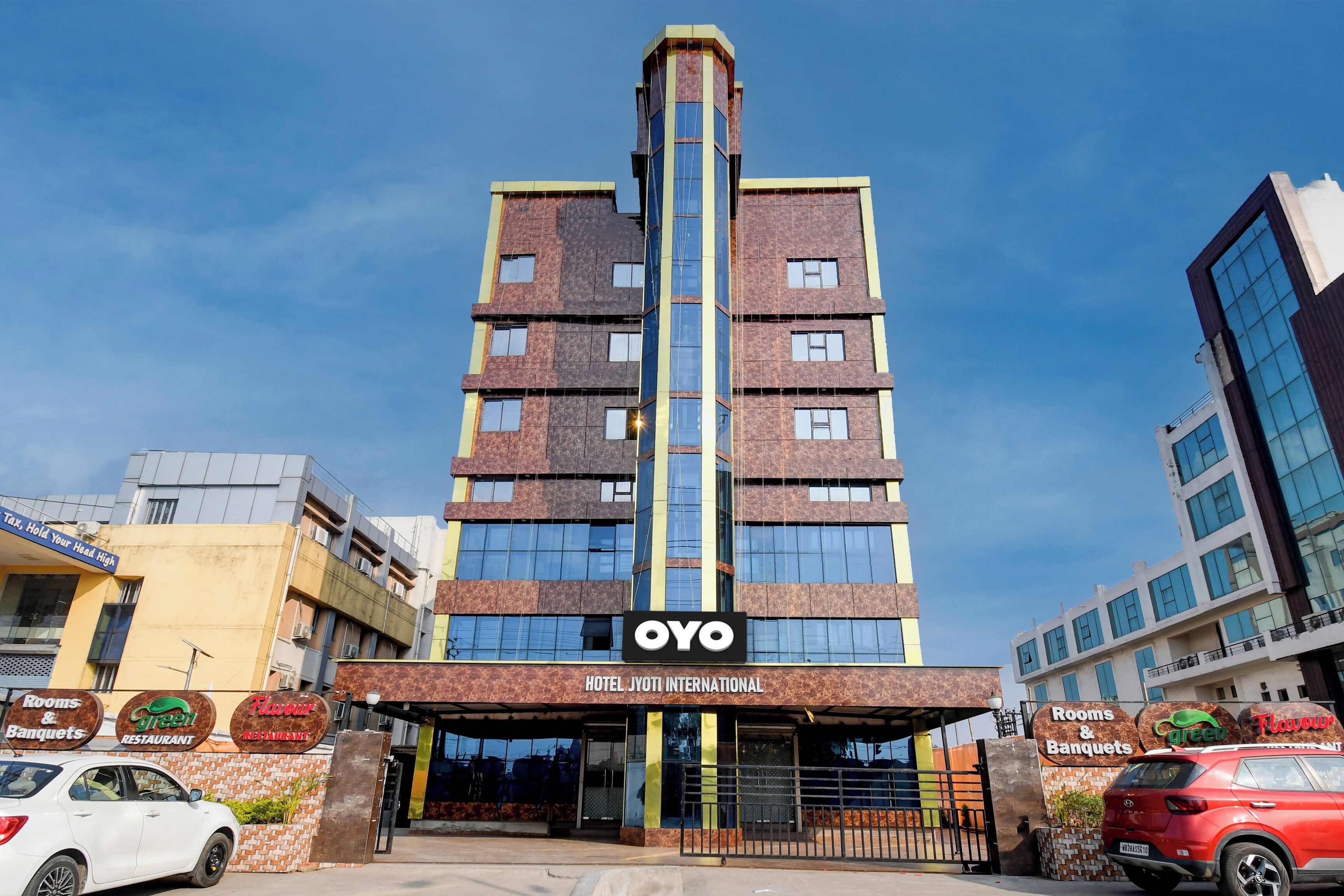 Un bâtiment d'hôtel avec une enseigne indiquant « Hôtel Jyoti International » et une autre indiquant « Chambres et salles de réception ».