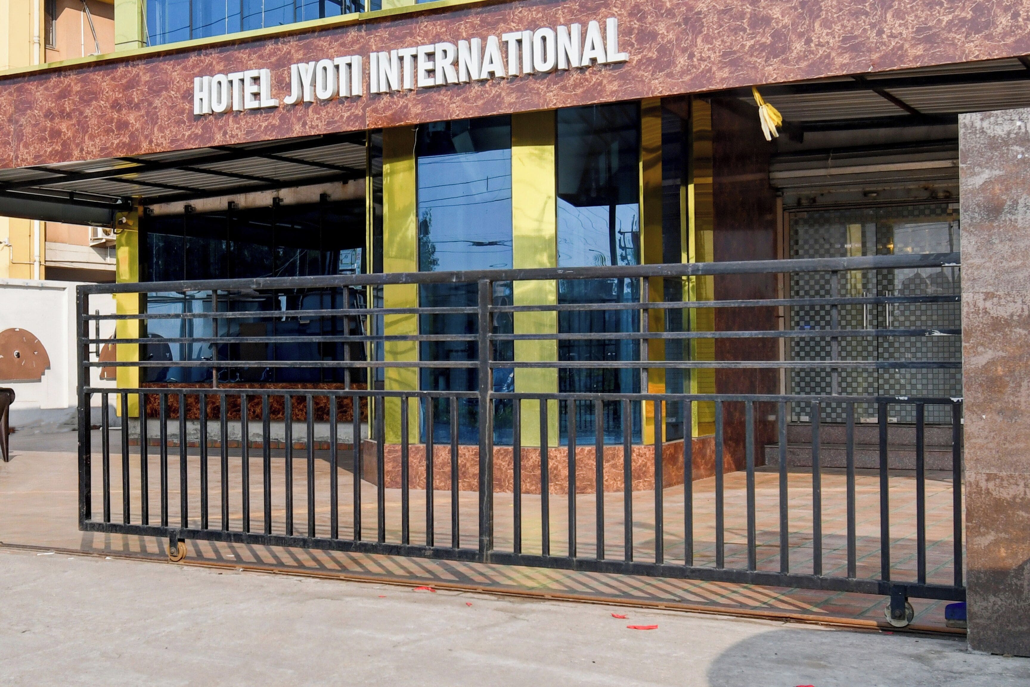 A hotel entrance with a metal gate and a sign that reads 'HOTEL JYOTI INTERNATIONAL'.