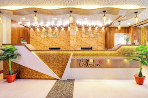 Un'area di reception di un hotel con un bancone in marmo, una scrivania e un cartello che indica il divieto di portare cibo dall'esterno.