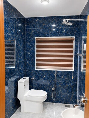 Un baño con inodoro, bidé y lavamanos.