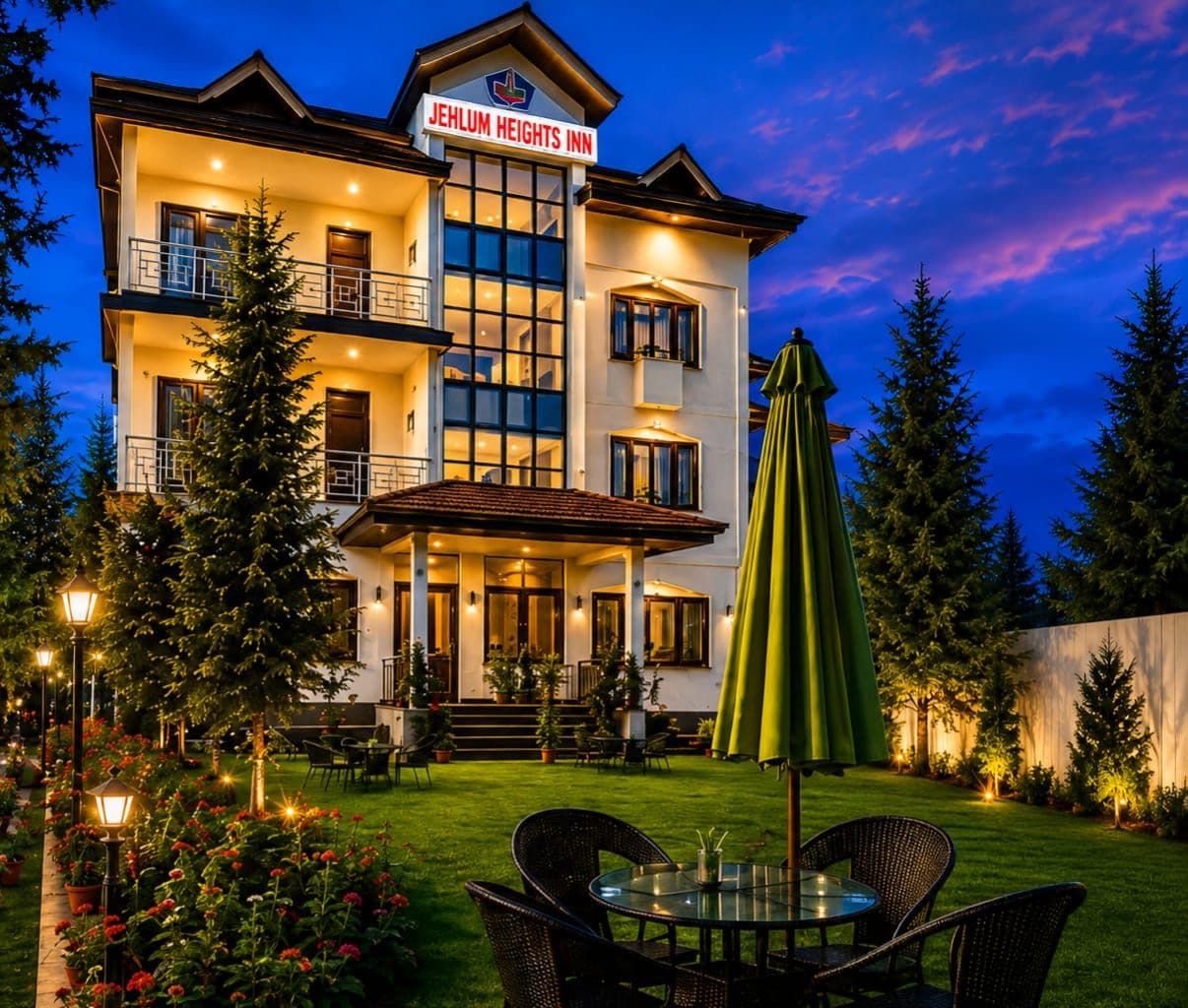 A two-story hotel with a balcony, a covered patio, and a well-lit outdoor seating area.