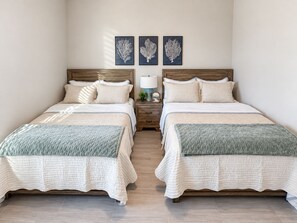 A double room with two beds, a nightstand with a lamp, and three wall-mounted artworks. - Happy Heron Cottage-Dog-Friendly, Near Beach + Boat Parking, 2kayaks, BBQ Pit (Rockport)