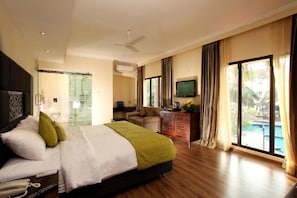 A hotel room with a bed, a television, a desk, and a view of a swimming pool. - Otium Resort by the Oterra (Alto de Porvorim)