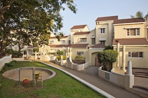 A residential area with multiple houses, a swing set, and a paved walkway. - Otium Resort by the Oterra (Alto de Porvorim)