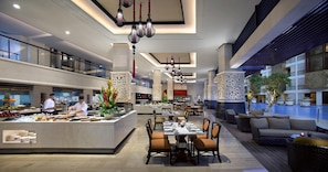 Una hall d'albergo moderna con un'area bar centrale, zona pranzo e un salotto a bordo piscina.