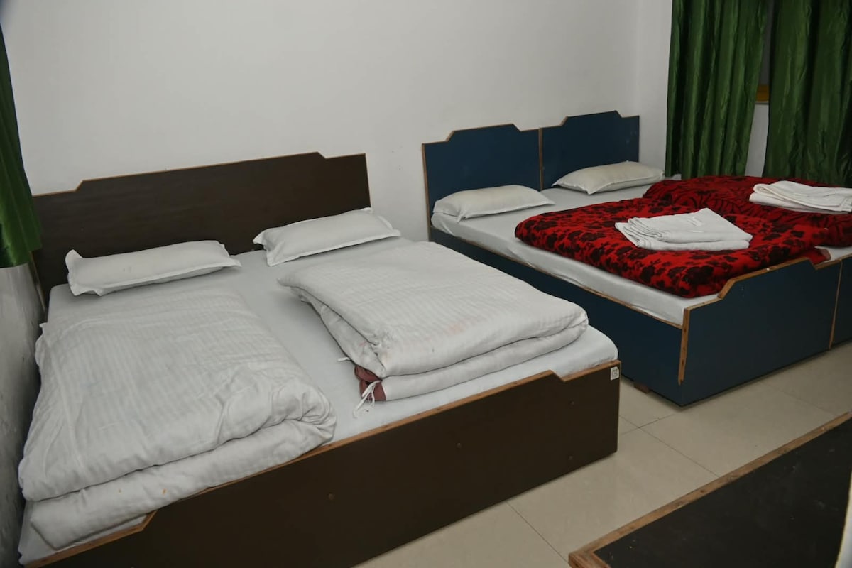 Ein Hotelzimmer mit zwei Einzelbetten, jeweils mit weißer Bettwäsche und dunklem Kopfteil.