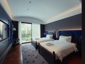 Una camera d'albergo con due letti, una grande finestra e vista sull'esterno.