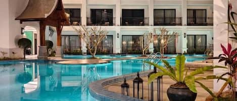 Un hôtel doté d’une piscine, de nombreux balcons et d’un style architectural traditionnel.