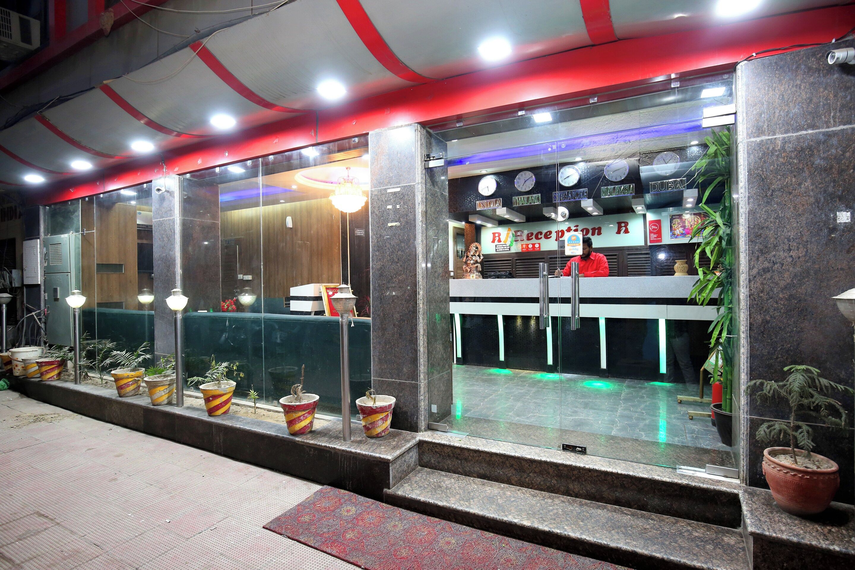 A reception area with a counter, potted plants, and a clock.