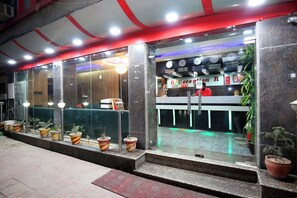 A reception area with a counter, potted plants, and a clock. - Hotel O by OYO Ishita Residency (Amritsar)
