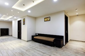 Ein Hotelzimmer mit Bett, Sitzbank, Schrank und Tür.