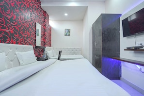 A modern bedroom with a white bed, a red and black patterned wall, a television on the wall, and a small picture frame. - Hotel O Shree Vishnu Residency (Amritsar)
