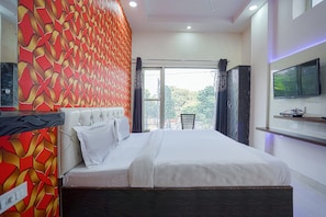 A bedroom with a bed, a television, and a view of the outdoors. - Hotel O Shree Vishnu Residency (Amritsar)