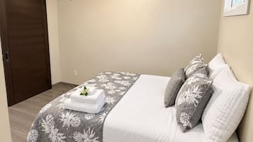 Een slaapkamer met een bed, een plafondventilator en een schuifdeur.