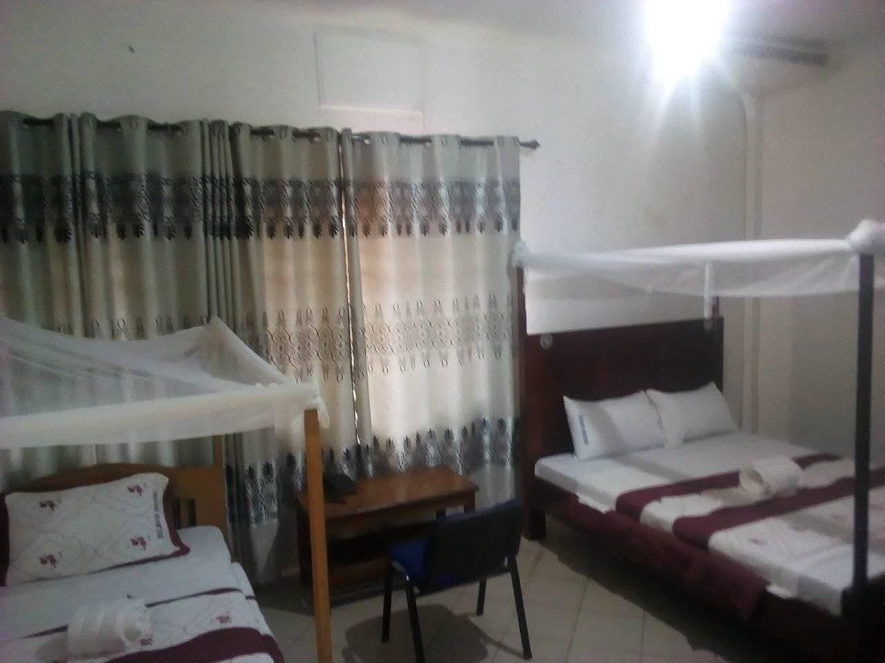 Una habitación de hotel con una cama, un escritorio y una silla.