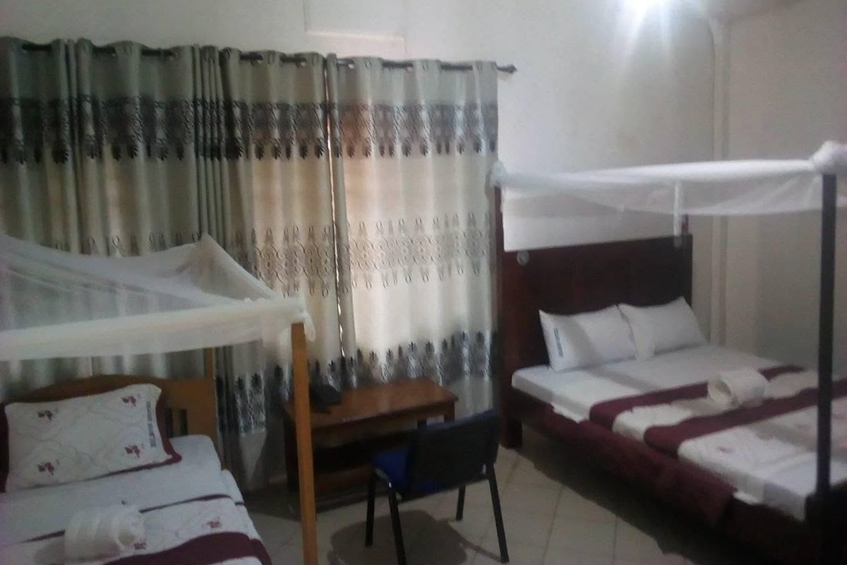 Una habitación de hotel con una cama, un escritorio y una silla.