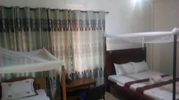 Una habitación de hotel con una cama, un escritorio y una silla.