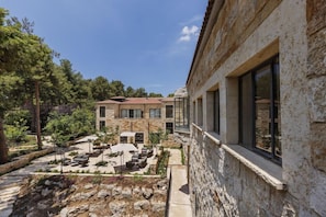 Un patio con mobiliario exterior y un edificio de piedra.