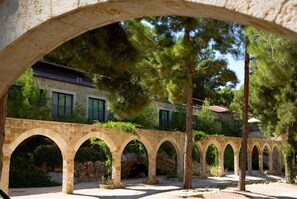 Un arco de piedra que conduce a un edificio con varias ventanas y techo.