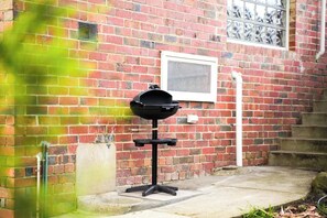 A barbecue grill in front of a brick building with a window and steps. - Seednest Stylish 4BR Retreat Near Chadstone (Mount Waverley)