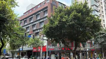 A multi-story building with commercial establishments on the ground floor, including a Canon store.