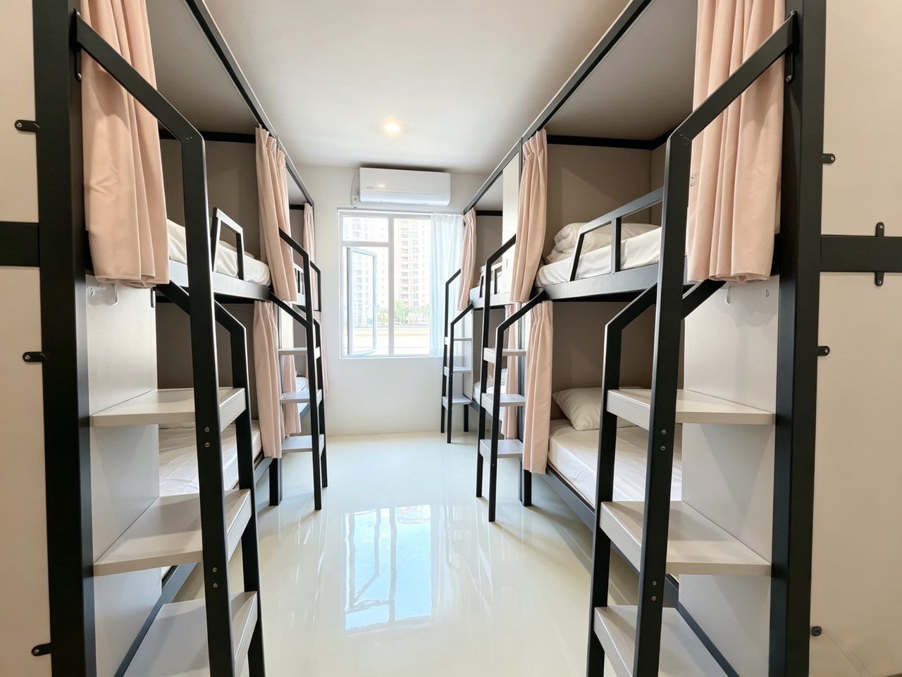 A corridor with bunk beds, a window, and an air conditioning unit.