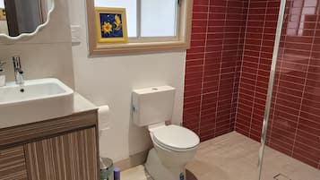 A bathroom with a sink, toilet, and shower.