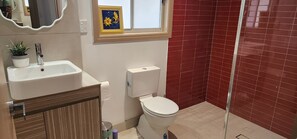 A bathroom with a sink, toilet, and shower.