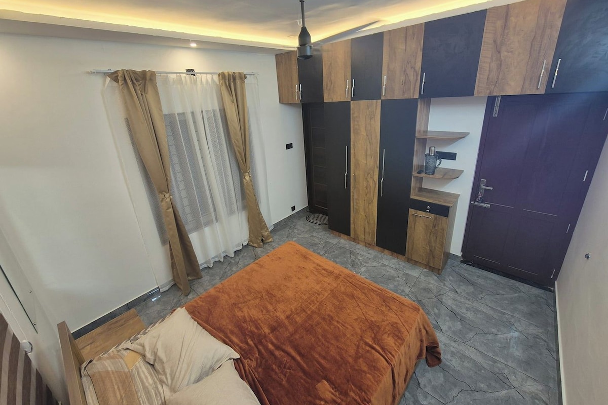 A bedroom with a bed, wardrobe, and a ceiling fan.