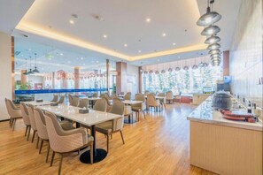 Un restaurante moderno con una mesa común larga, asientos individuales y una zona de bar.