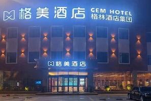 A hotel with a modern facade, illuminated signage, and a visible entrance. - Gem Anqing Wangjiang County Central Mall Fengqi Road Hotel (Anqing)