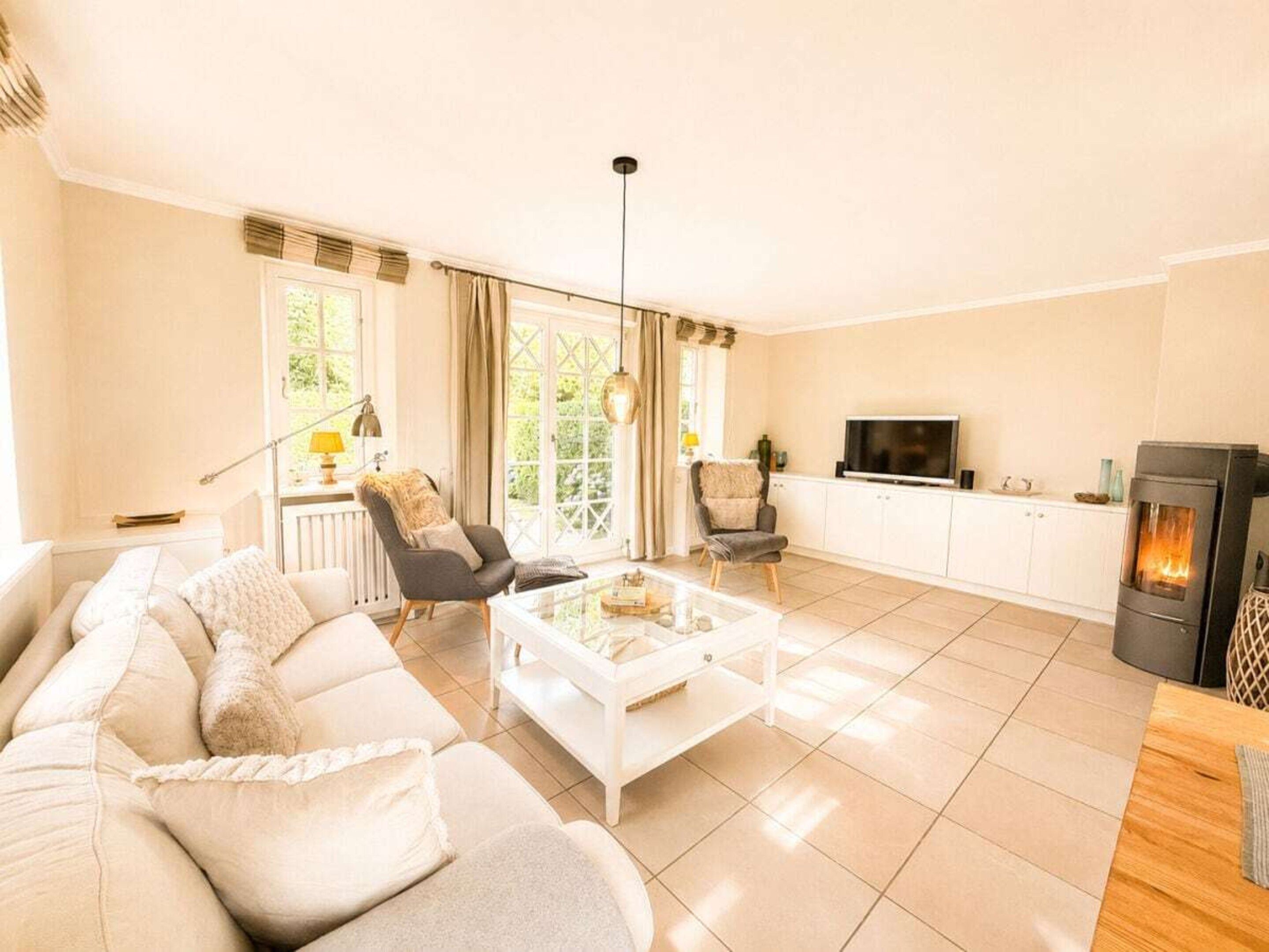 A living room with a sofa, chairs, a coffee table, a TV, and a fireplace.