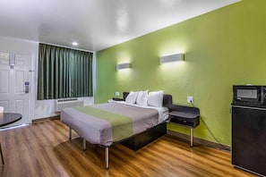 A hotel room with a bed, bedside table, and a television. - 1 King Bed | Non-Smoking, Micfridge (San Marcos)