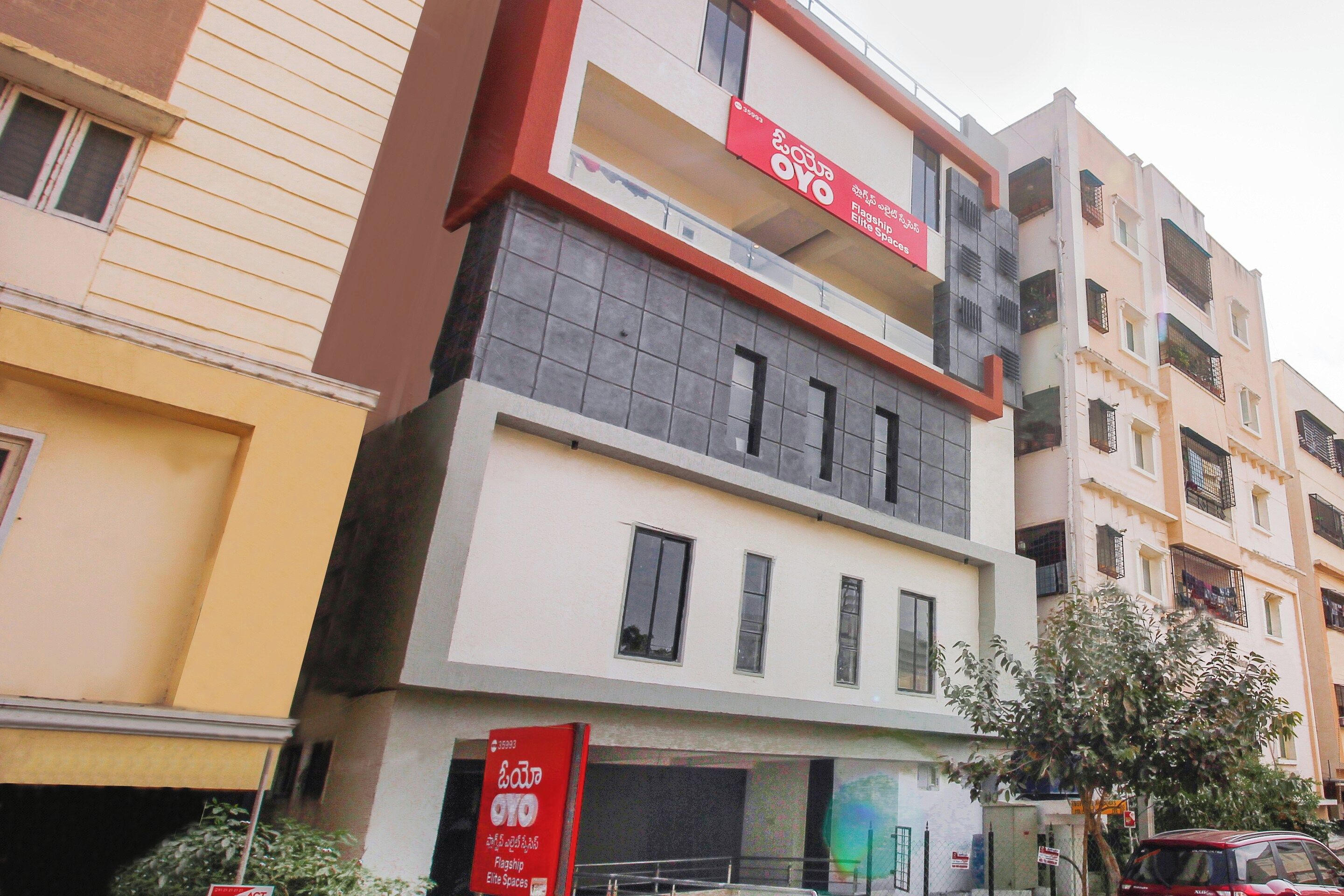 A multi-story building with a prominent red and white sign indicating 'Flagship Elite Spaces.'