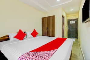 A hotel room with a bed, a wardrobe, a television, and a door. - Hotel O Adhin Residency (Hyderabad)