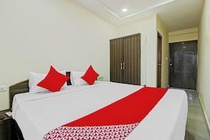 A hotel room with a bed, a wardrobe, and a door. - Hotel O Adhin Residency (Hyderabad)
