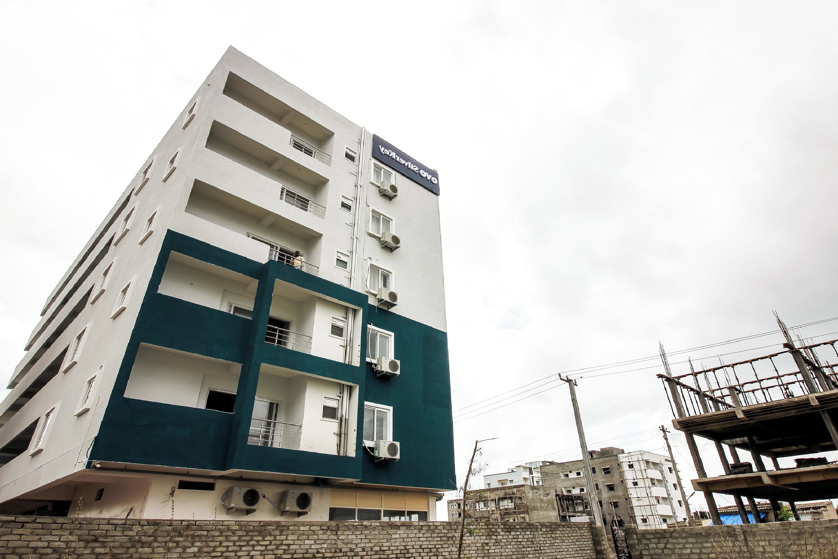 A multi-story building with balconies and air conditioning units.