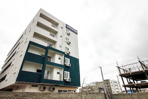 A multi-story building with balconies and air conditioning units.