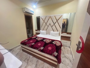 A hotel room with a bed, a mirror, a wardrobe, and a bathroom visible through an open door. - Hotel O Citizen Residency (Amritsar)
