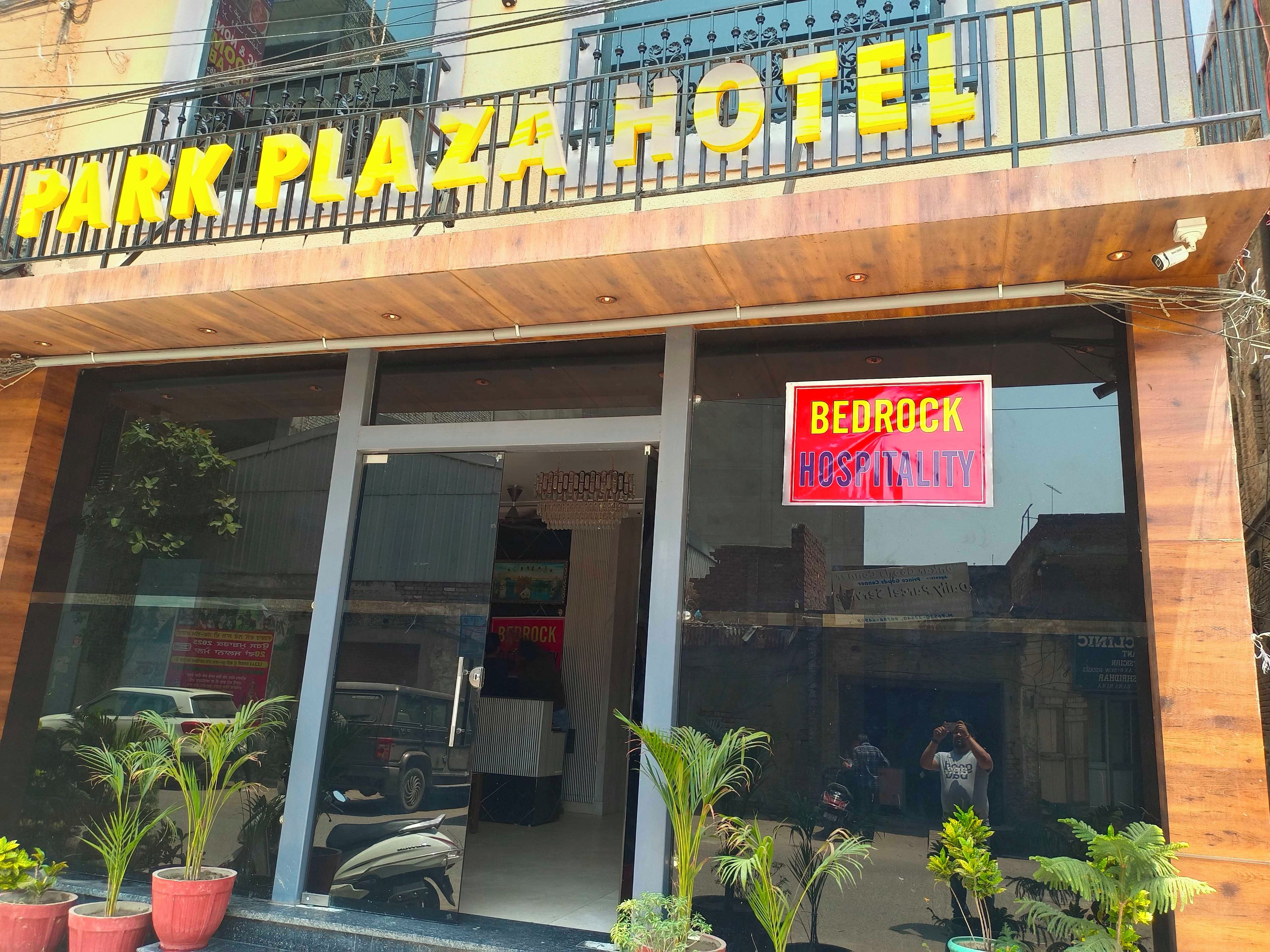 A hotel entrance with a sign reading 'Park Plaza Hotel' and a 'Bedrock Hospitality' sign.