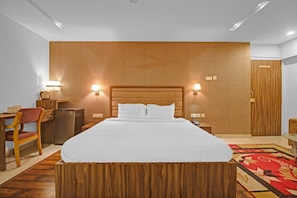 A hotel room with a large bed, a desk with a chair, a wardrobe, and two wall-mounted lamps. - Hotel O Rahul International Hyderabad (Hyderabad)